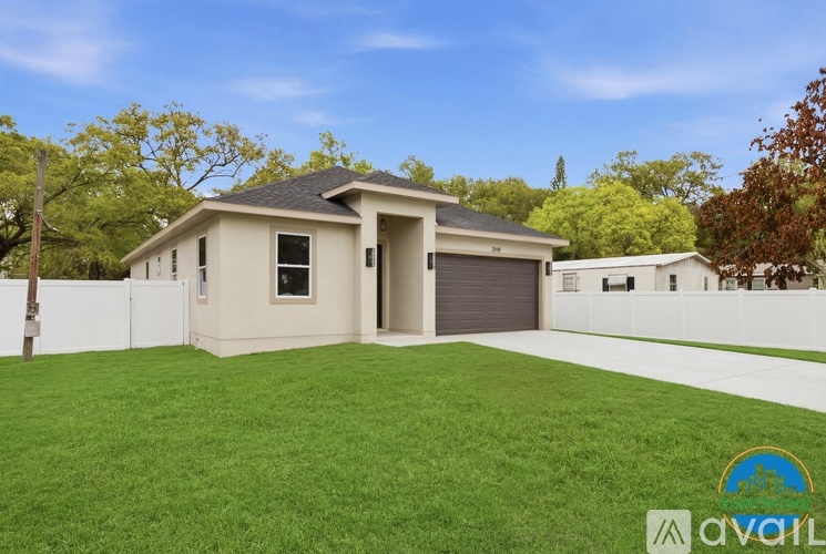 A house with a garage and a fence in front of it.