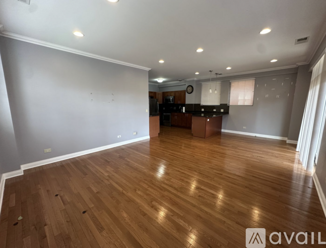 A room with wooden flooring and a white wall.