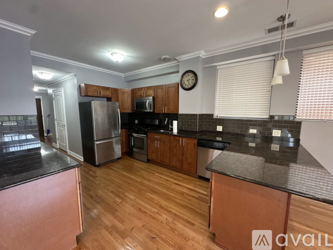 A kitchen with wooden cabinets and a black countertop.