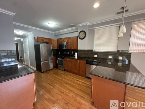 A kitchen with wooden cabinets and a black countertop.