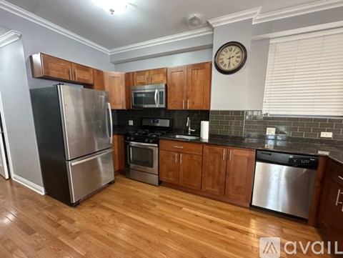 A kitchen with wooden cabinets and a stainless steel refrigerator.