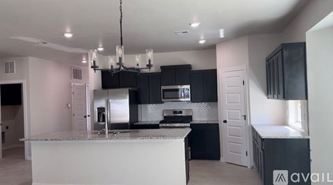 A kitchen with black cabinets and a white island.