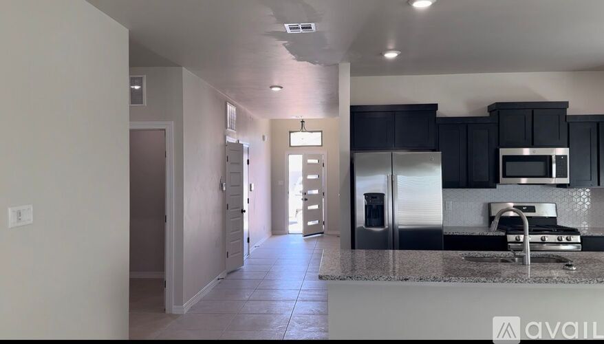 A kitchen with black cabinets and stainless steel appliances.