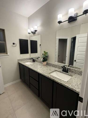 A bathroom with two sinks and a large mirror.
