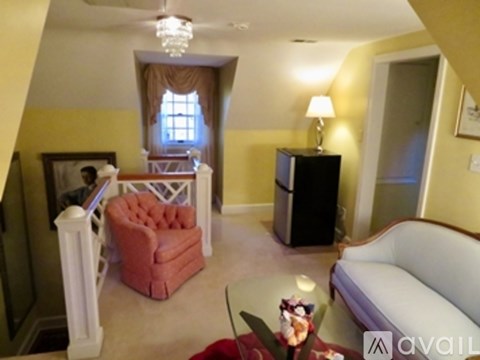 A living room with a red chair and a white sofa.