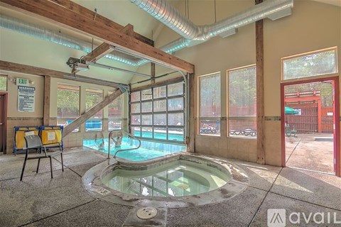A hot tub is in the middle of a room with a glass ceiling.