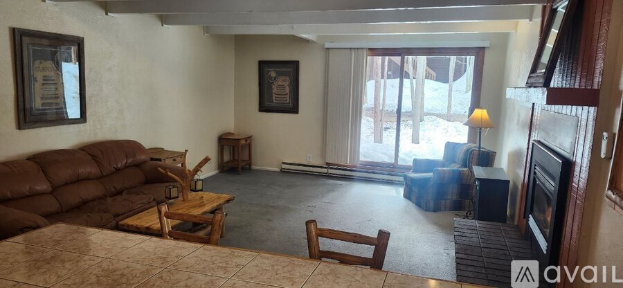 A living room with a brown couch and a fireplace.