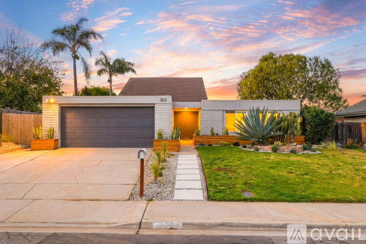 A house with a garage and a driveway in front of it.
