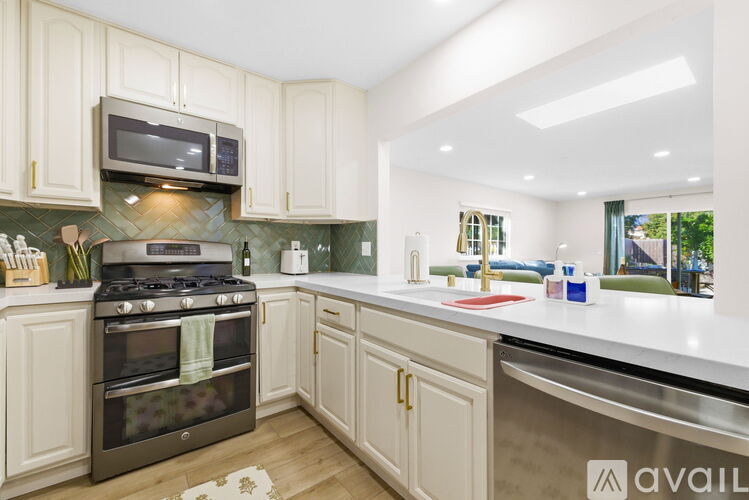 A kitchen with a black stove top oven and white cabinets.