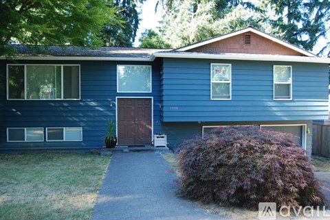 A blue house with a brown door and windows.