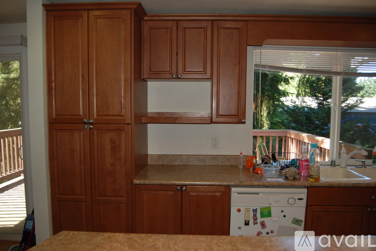 A kitchen with wooden cabinets and a white dishwasher.