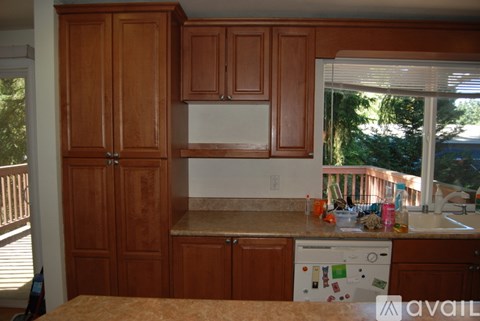 A kitchen with wooden cabinets and a white dishwasher.