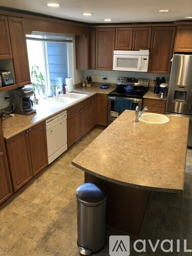 A kitchen with brown cabinets and a beige countertop.