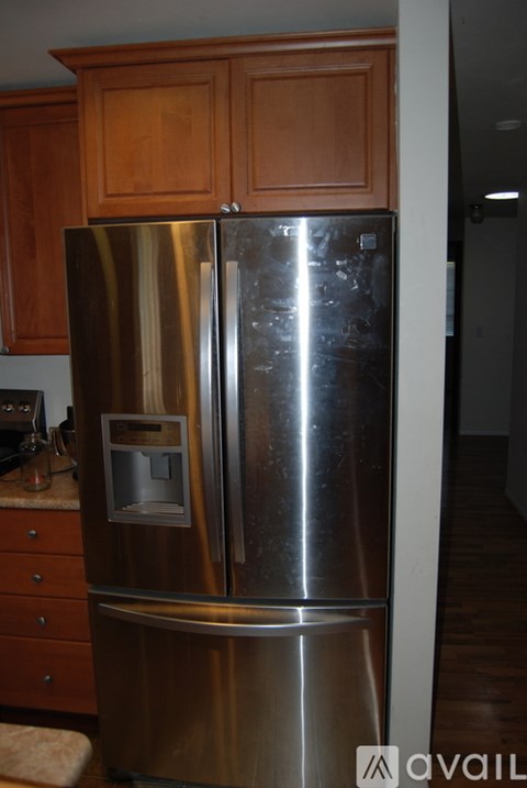 A stainless steel refrigerator with a freezer drawer and a water and ice dispenser.