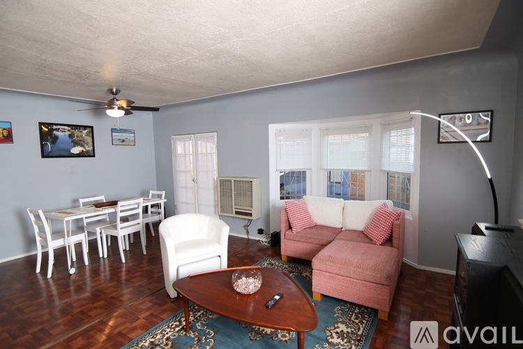 A living room with a white couch, a brown coffee table, and a ceiling fan.