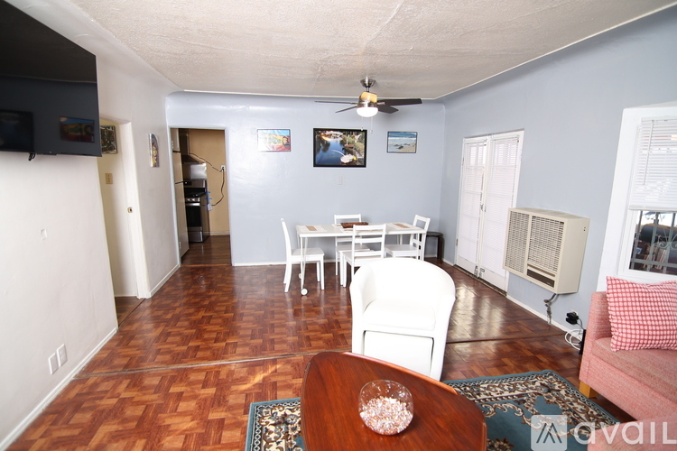 A living room with a wooden floor and a ceiling fan.