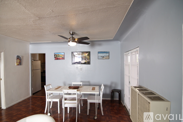 A dining room with a white table and chairs.