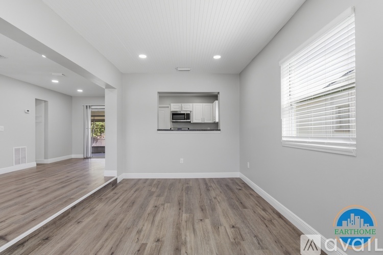 A spacious room with wooden floors and white walls.