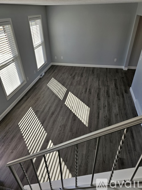 A wooden floor with a staircase and a window.