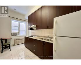 A kitchen with brown cabinets and a white refrigerator.