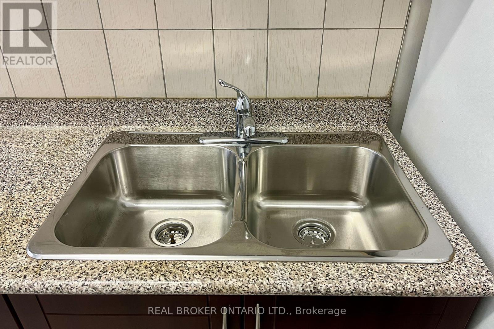 A double sink in a bathroom with a granite counter top.