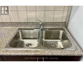 A double sink in a bathroom with a granite counter top.