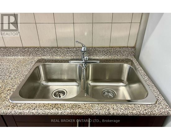 A double sink in a bathroom with a granite counter top.
