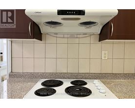 A white range hood with four burners below it.