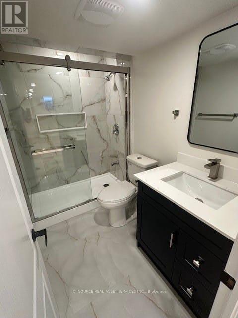 A modern bathroom with a glass shower enclosure and a white countertop.