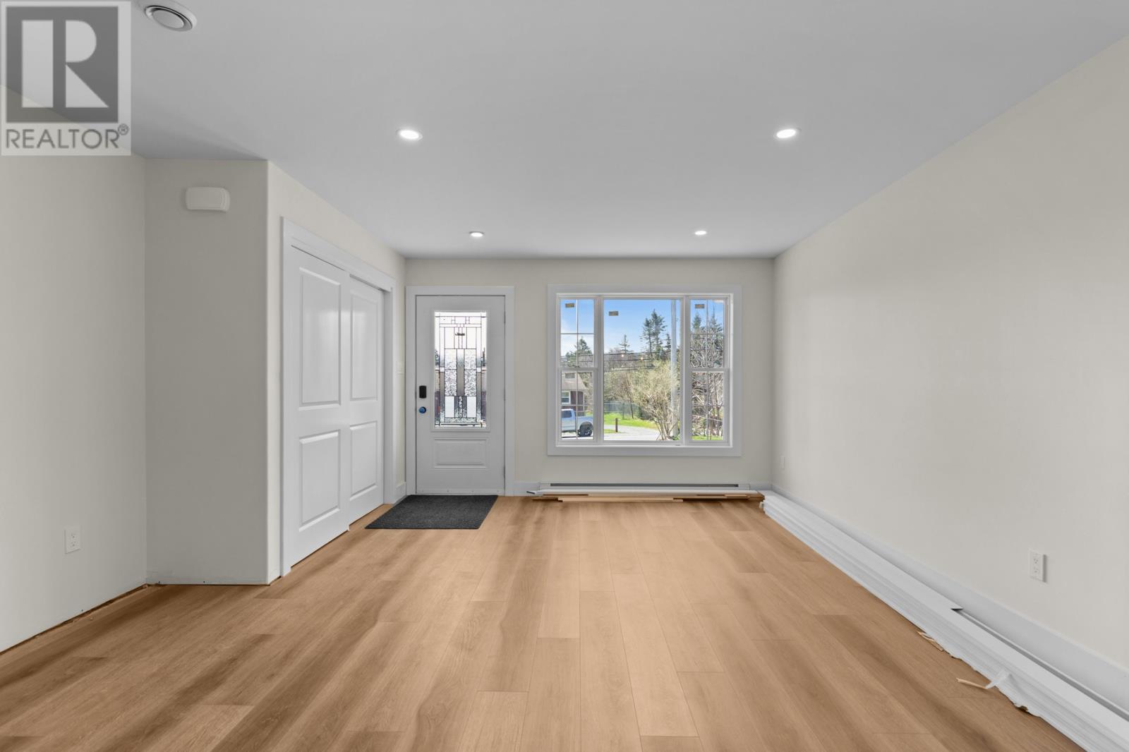 A spacious room with wooden floors and white walls.