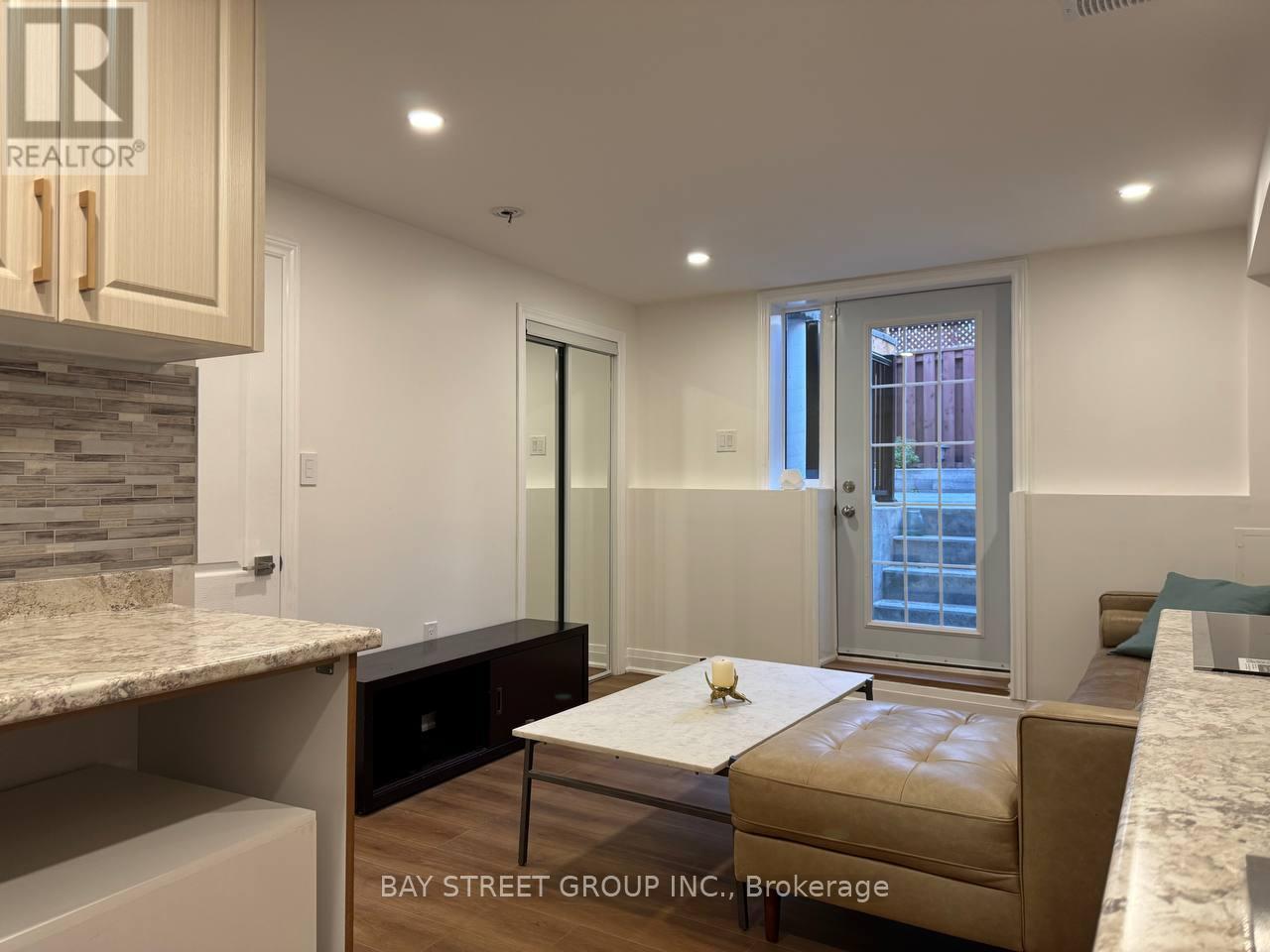 A modern kitchen with a marble countertop and a wooden table.