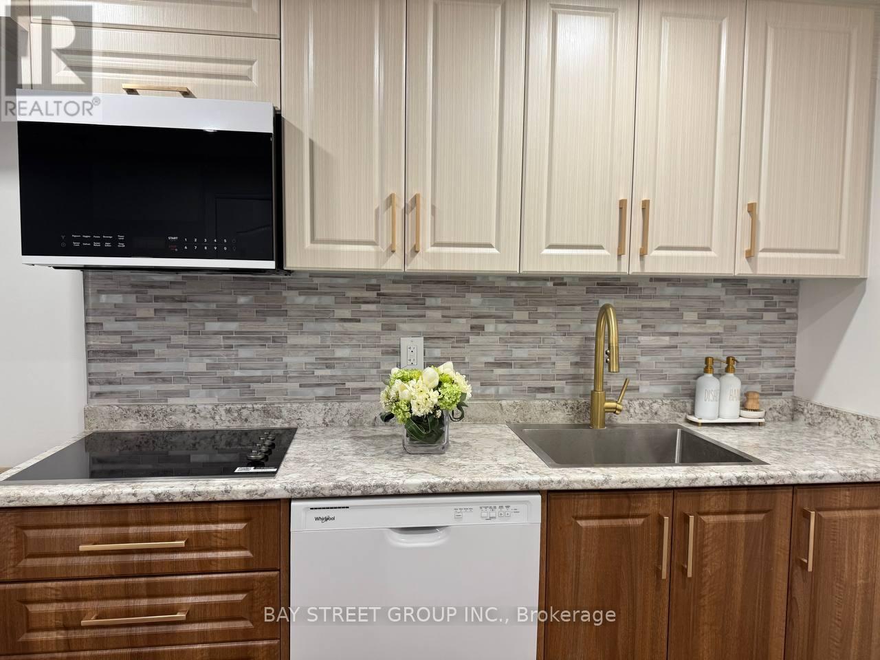 A kitchen with a microwave, dishwasher, and sink.