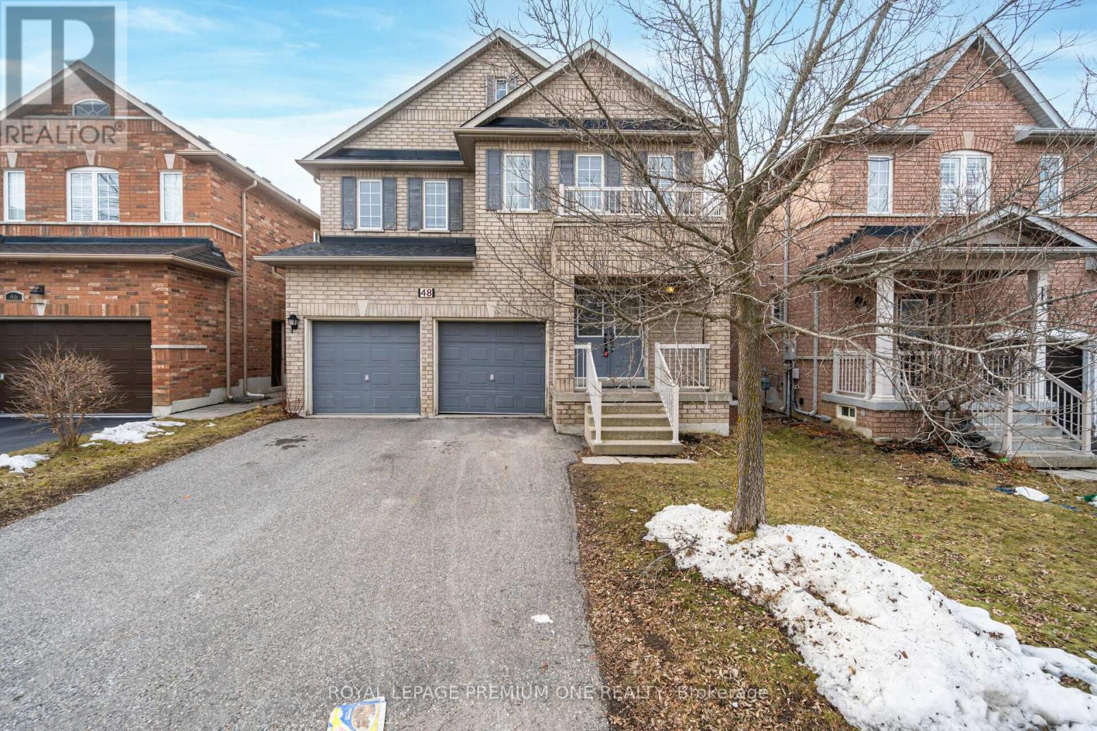 A large brick house with a driveway in front.
