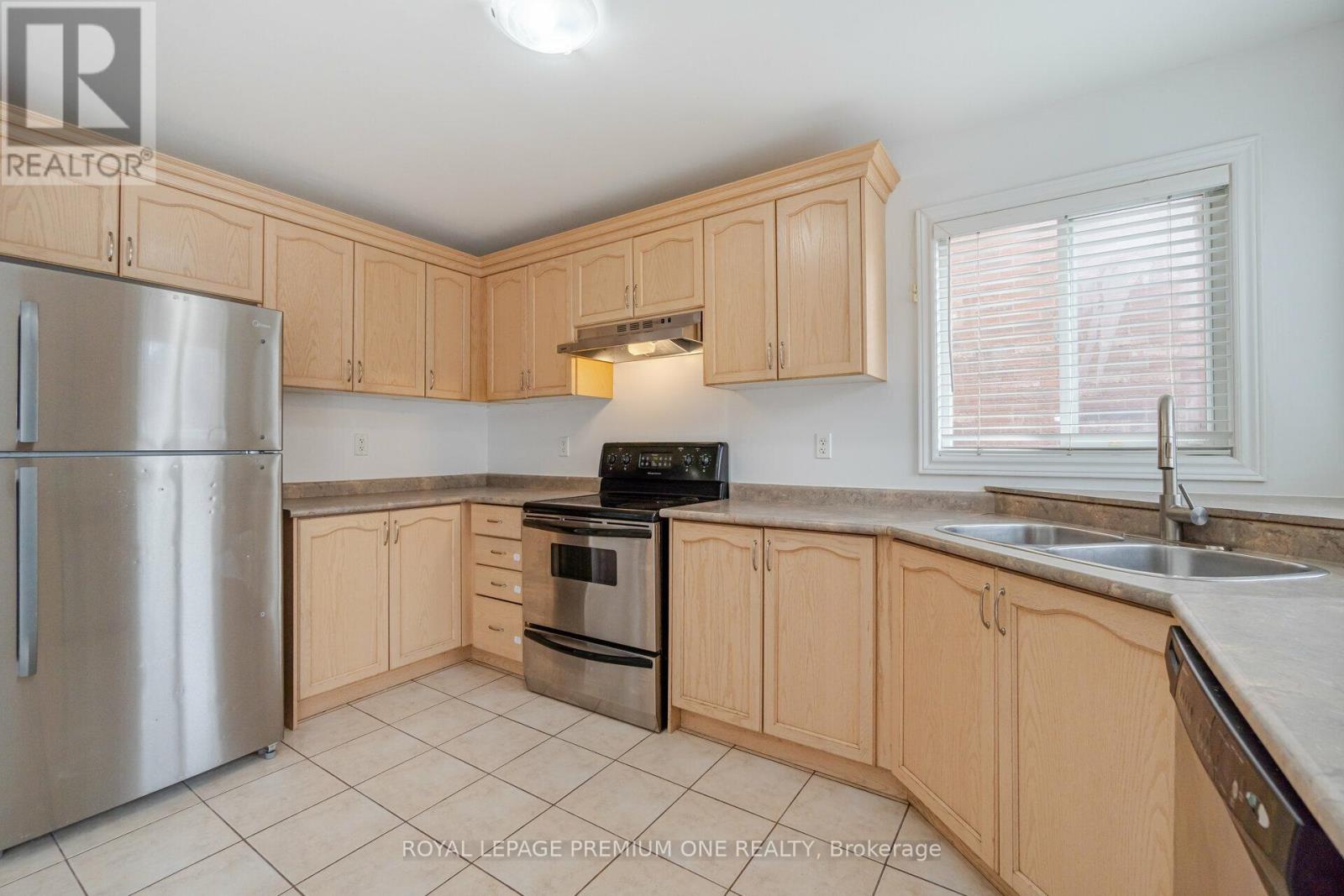 A kitchen with wooden cabinets and a stainless steel refrigerator.
