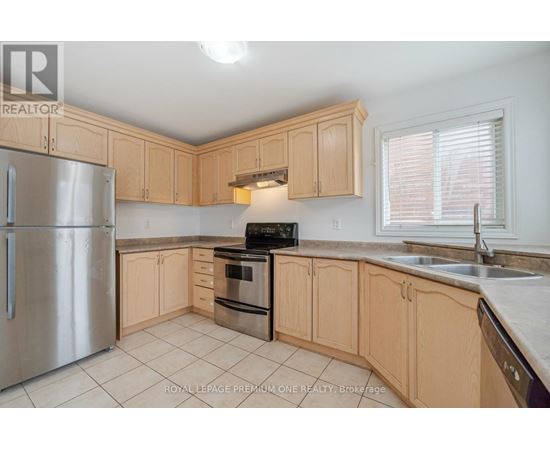 A kitchen with wooden cabinets and a stainless steel refrigerator.