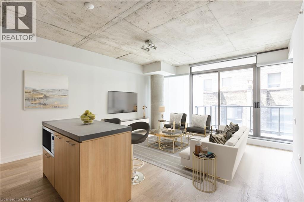 A modern living room with a kitchenette and a view of the city.