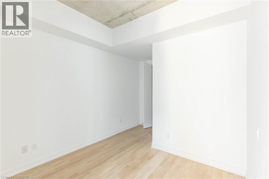 A spacious room with wooden flooring and white walls.