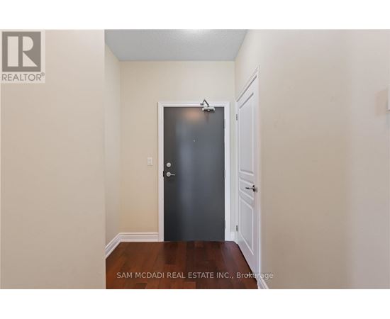 A black door is in the middle of a hallway.