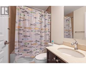 A bathroom with a shower curtain featuring fish patterns.