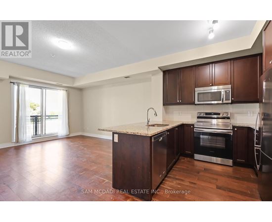 A kitchen with brown cabinets and a wooden floor.