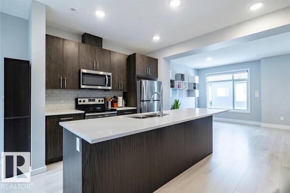 A modern kitchen with dark wood cabinets and a white island.
