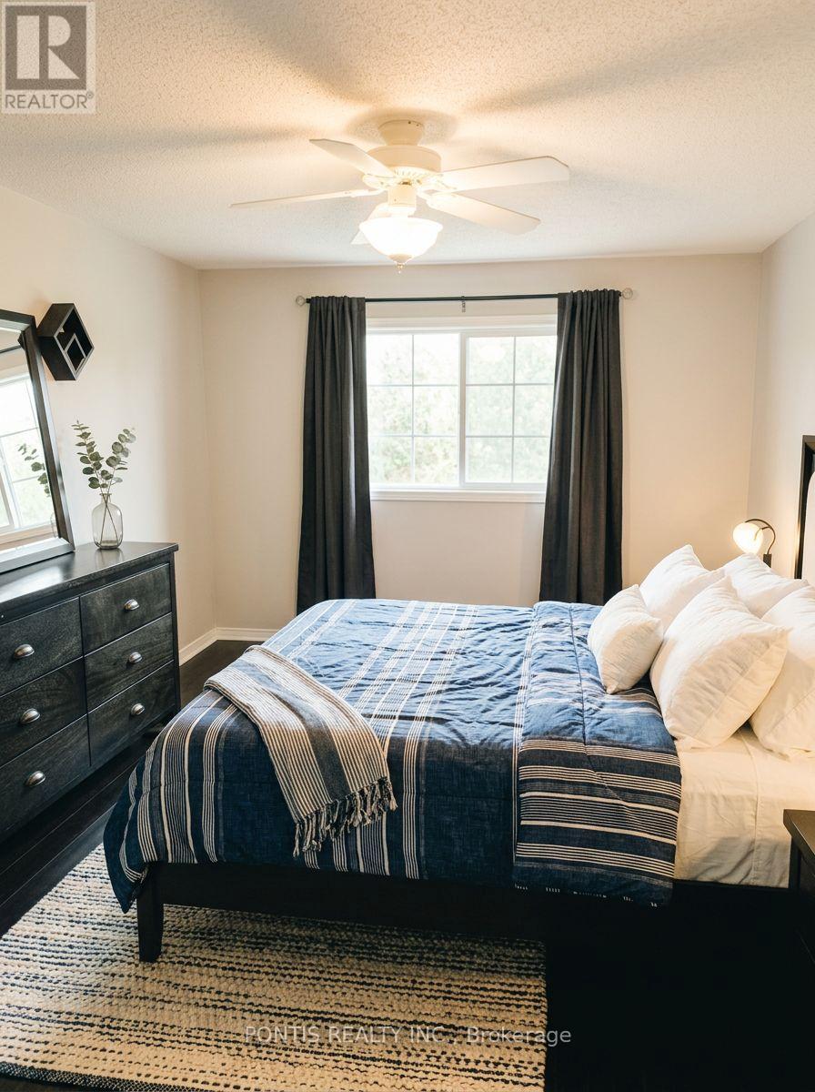 A bedroom with a bed, dresser, and ceiling fan.