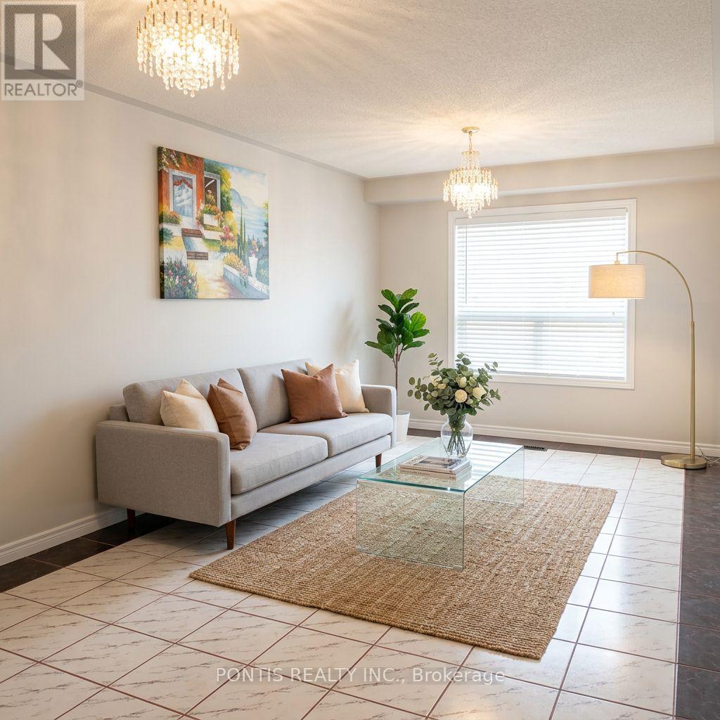A living room with a grey couch, a glass coffee table, and a painting on the wall.