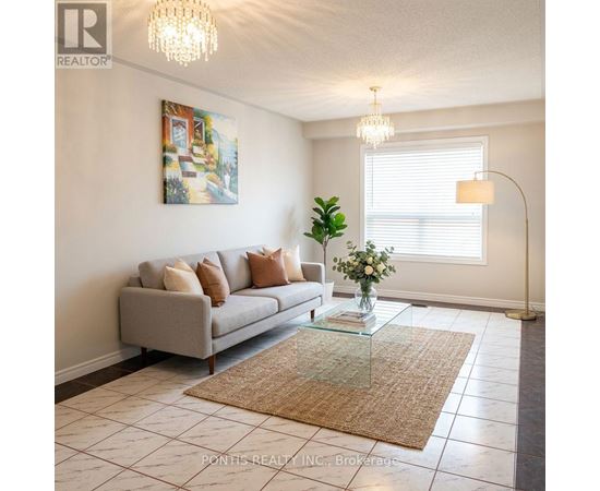 A living room with a grey couch, a glass coffee table, and a painting on the wall.