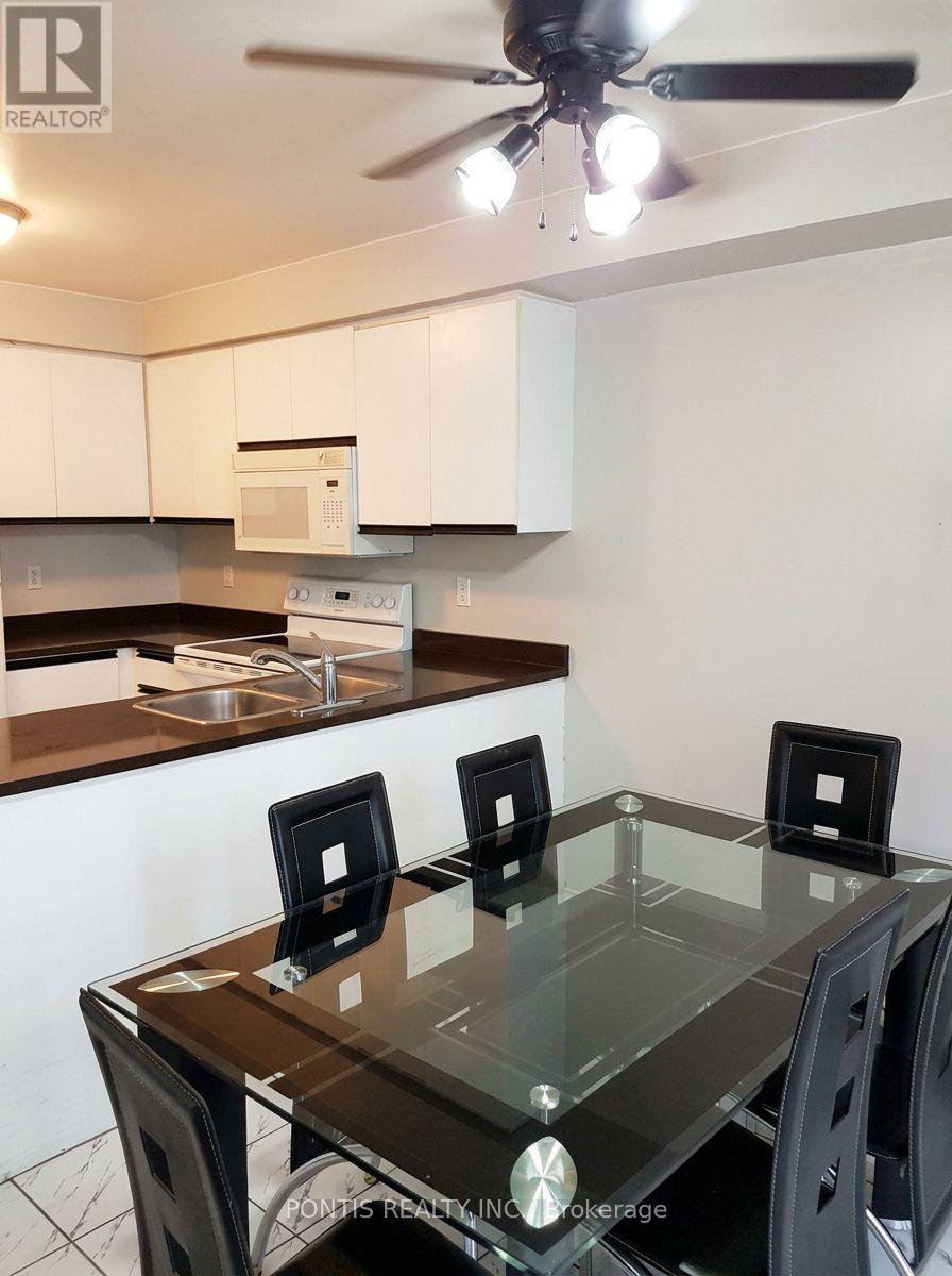 A kitchen with a table and chairs in the foreground.