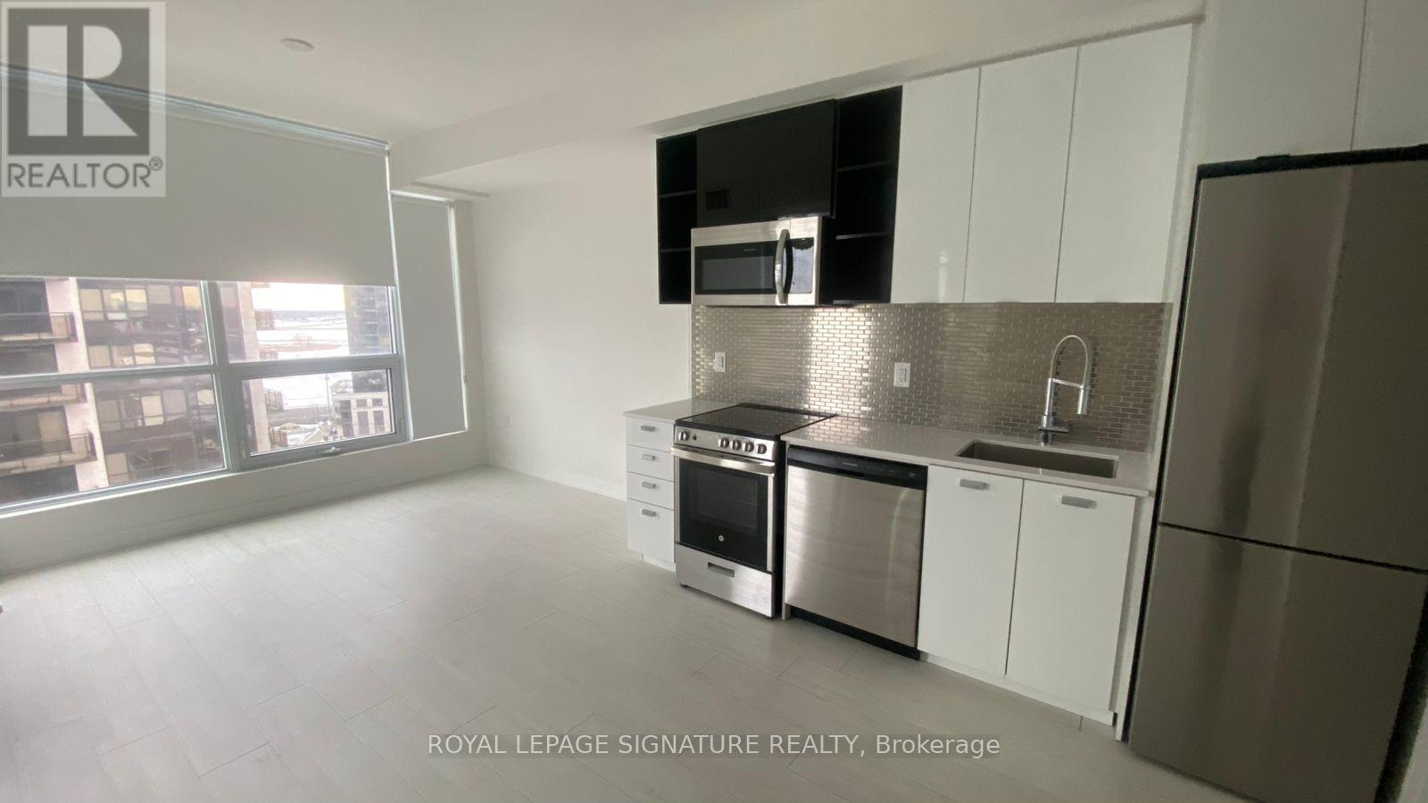 A modern kitchen with stainless steel appliances and white cabinets.