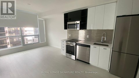 A modern kitchen with stainless steel appliances and white cabinets.