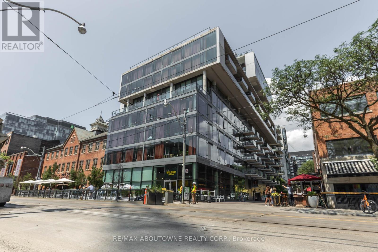 A modern multi-story building with glass windows is the focal point of the image.