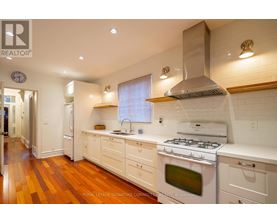 A modern kitchen with white cabinets and a stainless steel range hood.