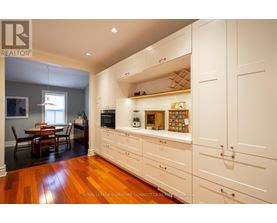 A kitchen with white cabinets and wooden floors.